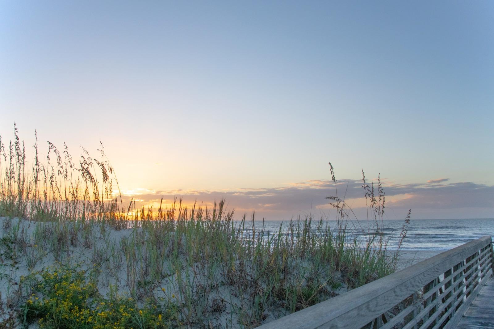 Two lounge chairs on the beach with ocean waves breaking on the shore